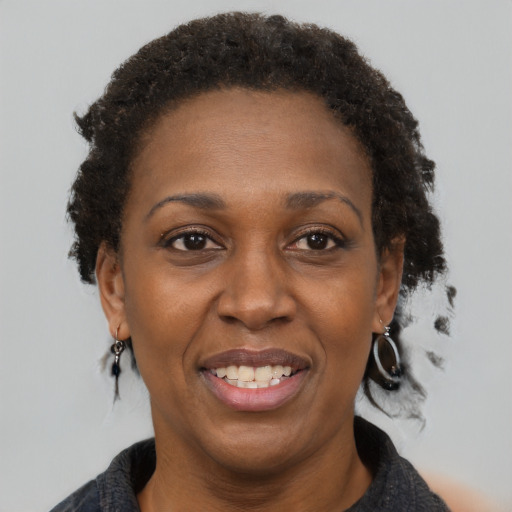 Joyful black adult female with short  brown hair and brown eyes