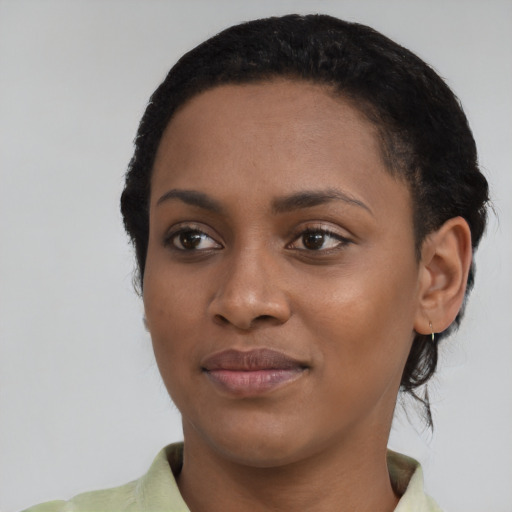Joyful black young-adult female with short  black hair and brown eyes