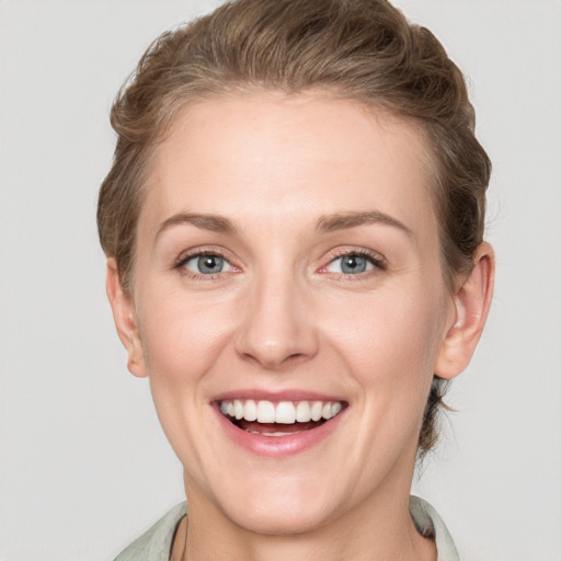 Joyful white young-adult female with short  brown hair and grey eyes