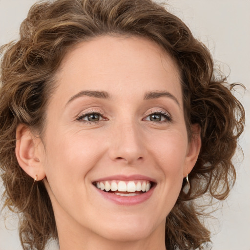 Joyful white young-adult female with medium  brown hair and green eyes