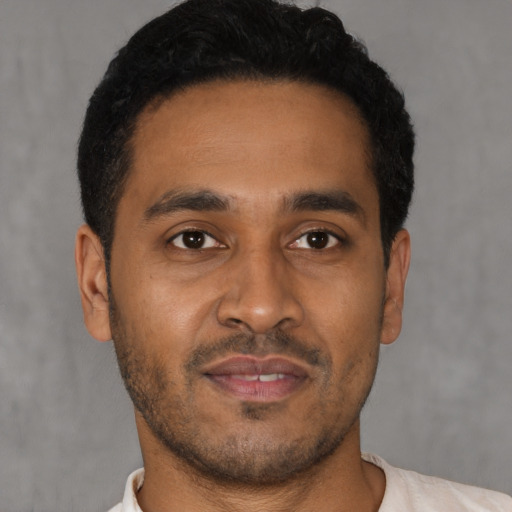 Joyful latino young-adult male with short  brown hair and brown eyes
