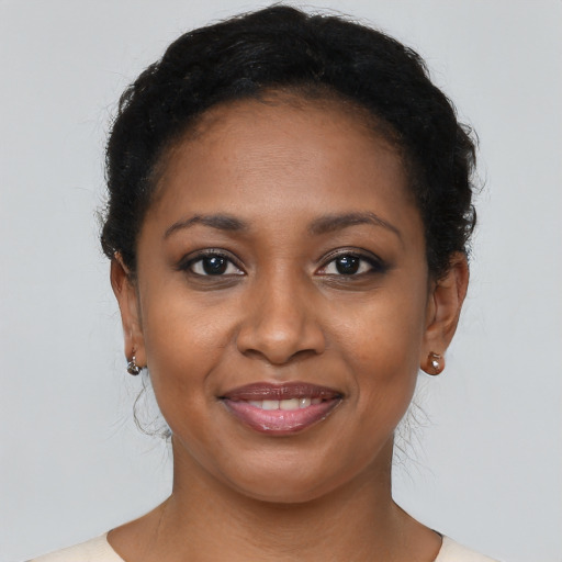 Joyful black young-adult female with short  brown hair and brown eyes