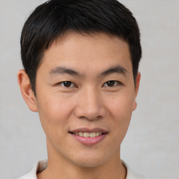 Joyful asian young-adult male with short  brown hair and brown eyes