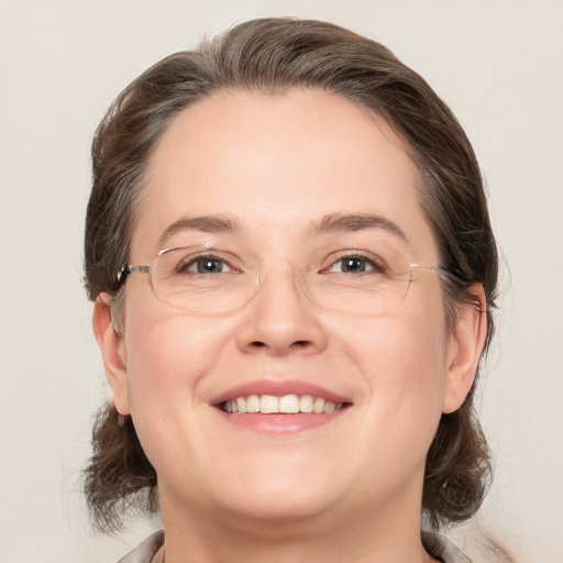 Joyful white adult female with medium  brown hair and grey eyes