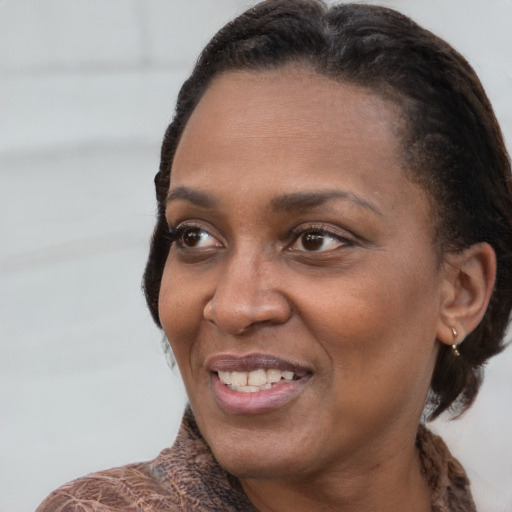 Joyful black adult female with medium  brown hair and brown eyes