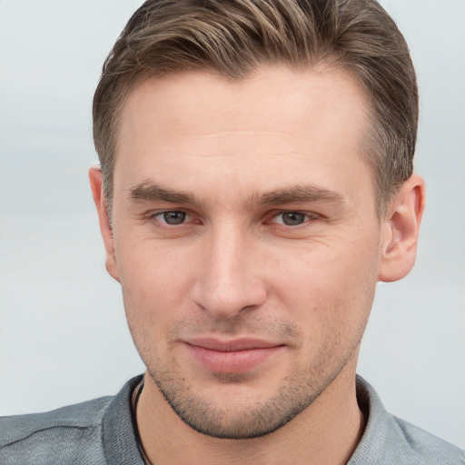 Joyful white young-adult male with short  brown hair and grey eyes