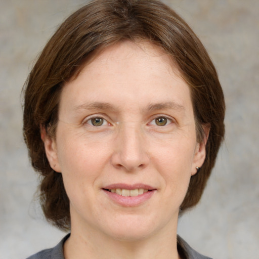 Joyful white adult female with medium  brown hair and grey eyes