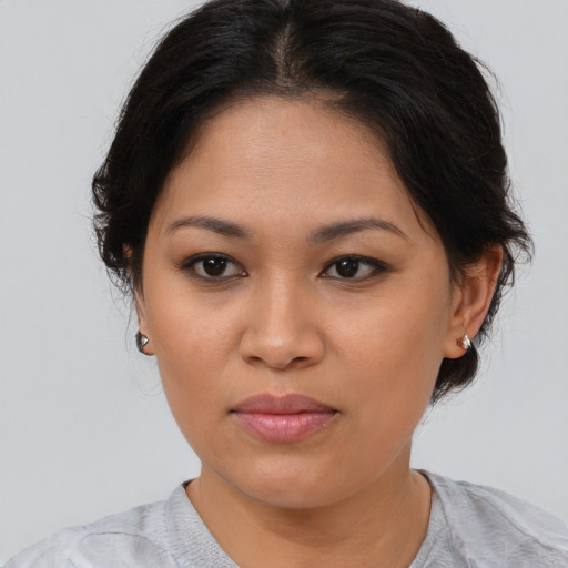 Joyful latino young-adult female with medium  brown hair and brown eyes