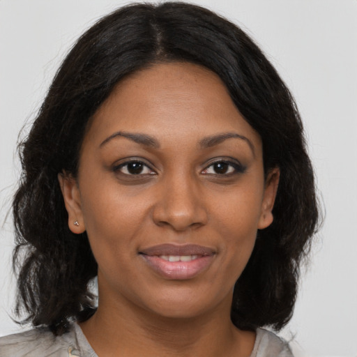 Joyful black young-adult female with medium  brown hair and brown eyes