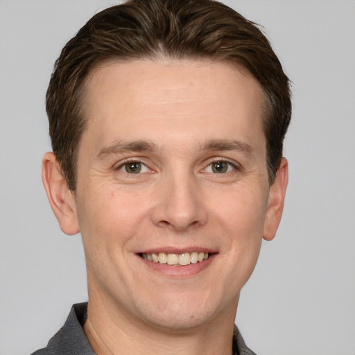 Joyful white adult male with short  brown hair and grey eyes