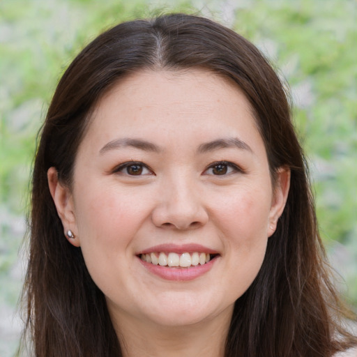 Joyful white young-adult female with long  brown hair and brown eyes