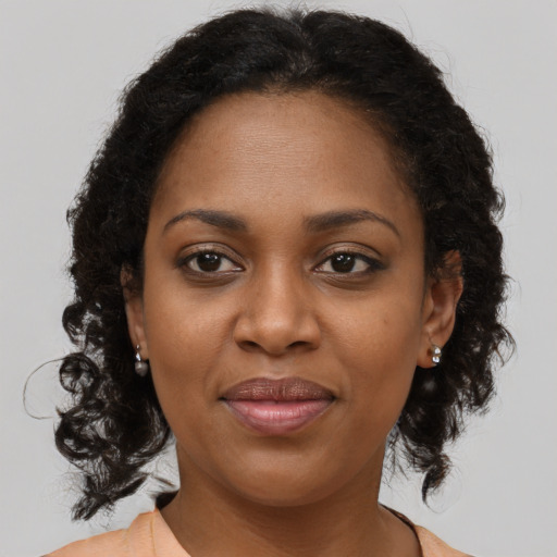 Joyful black adult female with long  brown hair and brown eyes