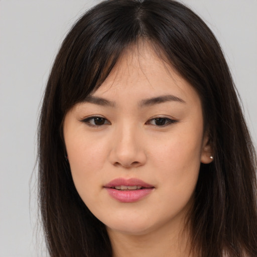 Joyful asian young-adult female with long  brown hair and brown eyes