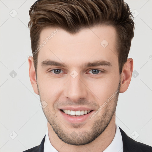 Joyful white young-adult male with short  brown hair and grey eyes