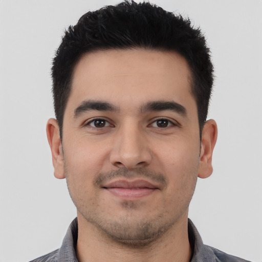 Joyful latino young-adult male with short  black hair and brown eyes