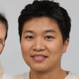 Joyful asian young-adult male with short  brown hair and brown eyes