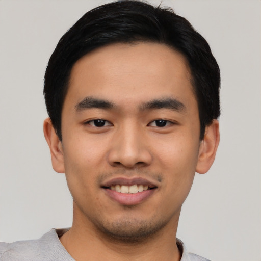 Joyful asian young-adult male with short  black hair and brown eyes
