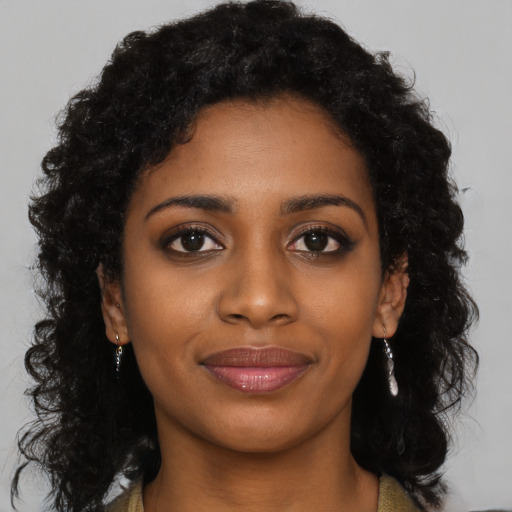 Joyful black young-adult female with long  black hair and brown eyes