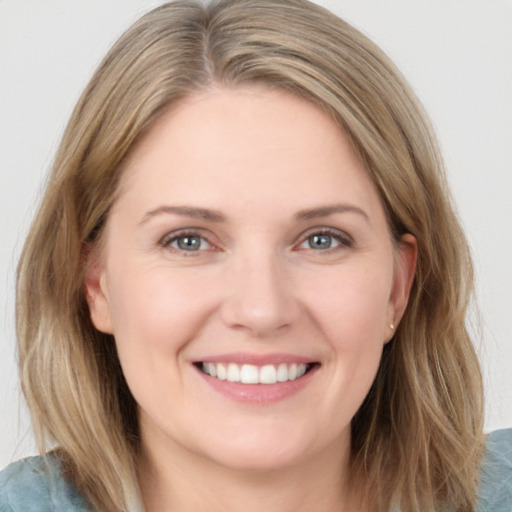 Joyful white young-adult female with long  brown hair and grey eyes