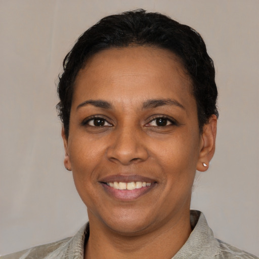Joyful black adult female with short  black hair and brown eyes