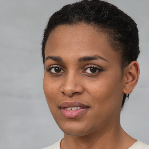 Joyful black young-adult female with short  brown hair and brown eyes