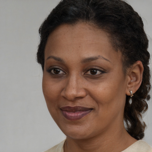 Joyful black adult female with medium  brown hair and brown eyes