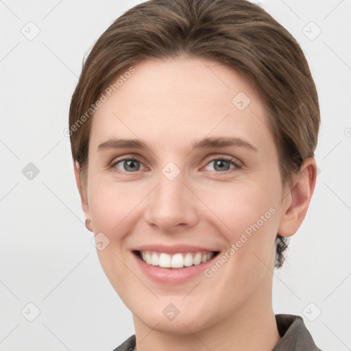 Joyful white young-adult female with short  brown hair and grey eyes