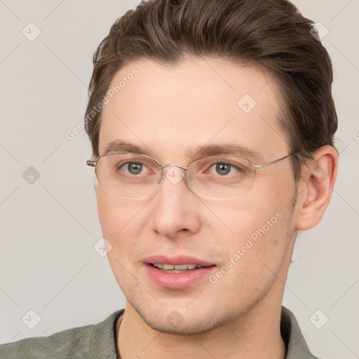 Joyful white young-adult male with short  brown hair and grey eyes