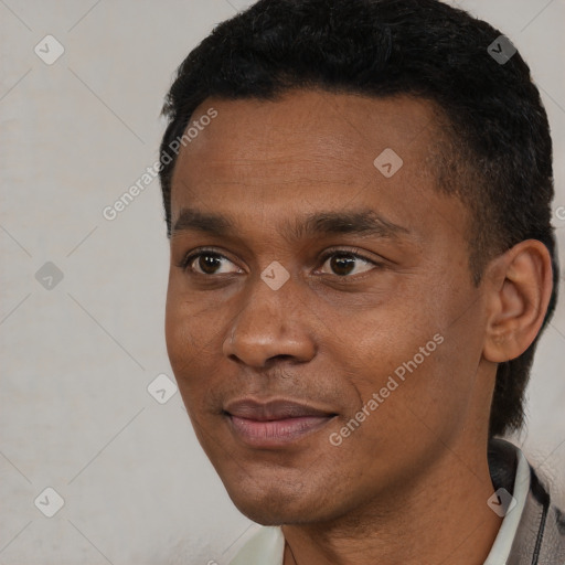 Joyful black young-adult male with short  black hair and brown eyes