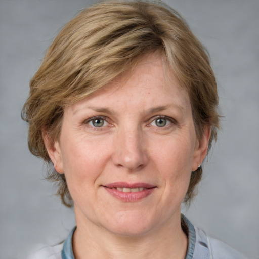 Joyful white adult female with medium  brown hair and blue eyes