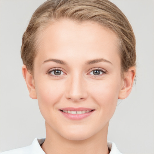 Joyful white young-adult female with short  brown hair and grey eyes