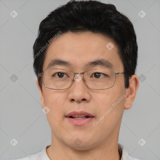 Joyful asian adult male with short  black hair and brown eyes