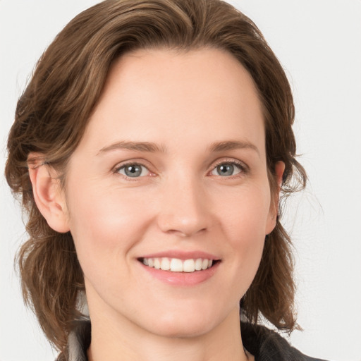 Joyful white young-adult female with medium  brown hair and grey eyes