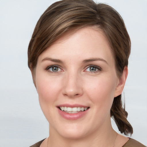 Joyful white young-adult female with medium  brown hair and grey eyes