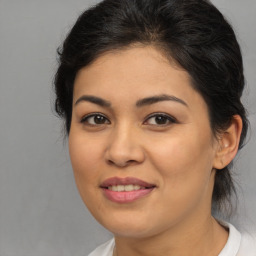 Joyful latino young-adult female with medium  brown hair and brown eyes