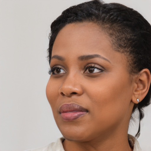 Joyful black young-adult female with medium  black hair and brown eyes