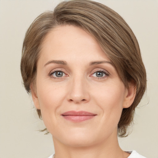 Joyful white adult female with medium  brown hair and green eyes