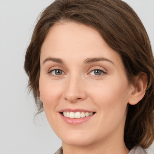 Joyful white young-adult female with medium  brown hair and green eyes