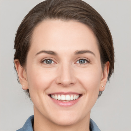 Joyful white young-adult female with medium  brown hair and grey eyes