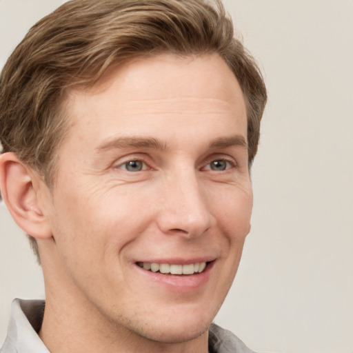 Joyful white adult male with short  brown hair and grey eyes