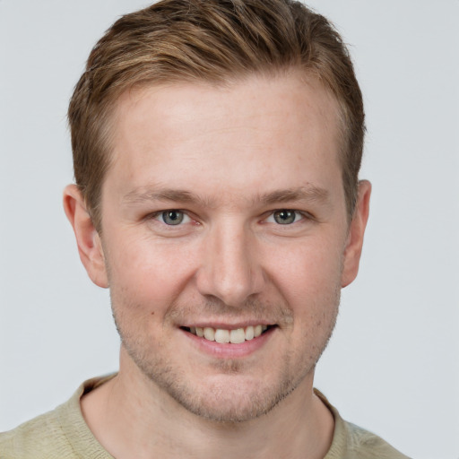 Joyful white young-adult male with short  brown hair and grey eyes