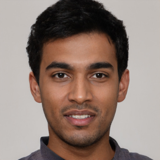 Joyful latino young-adult male with short  black hair and brown eyes