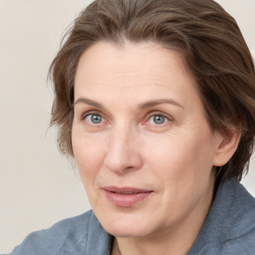 Joyful white adult female with medium  brown hair and grey eyes