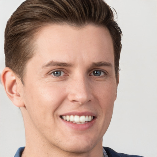 Joyful white young-adult male with short  brown hair and grey eyes