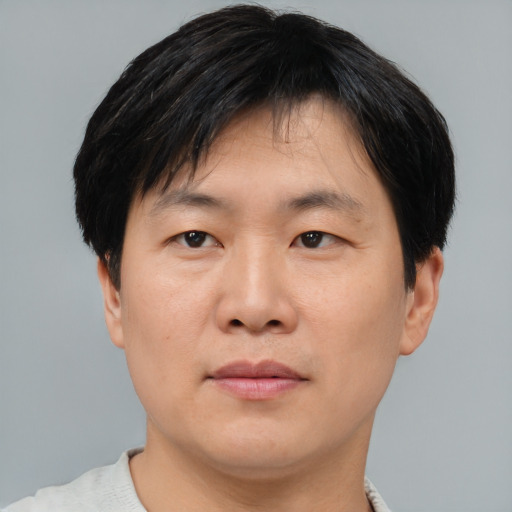 Joyful asian adult male with short  brown hair and brown eyes