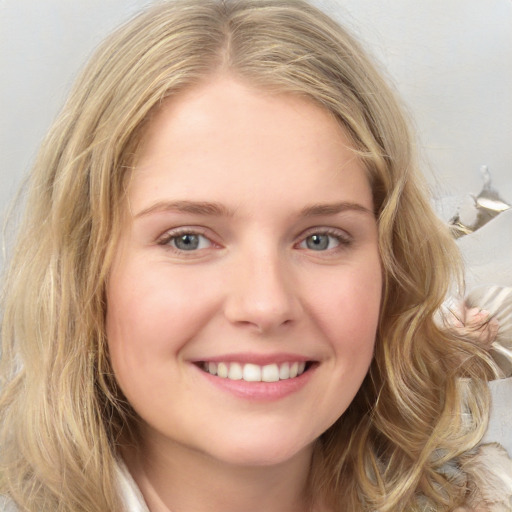 Joyful white young-adult female with medium  blond hair and brown eyes