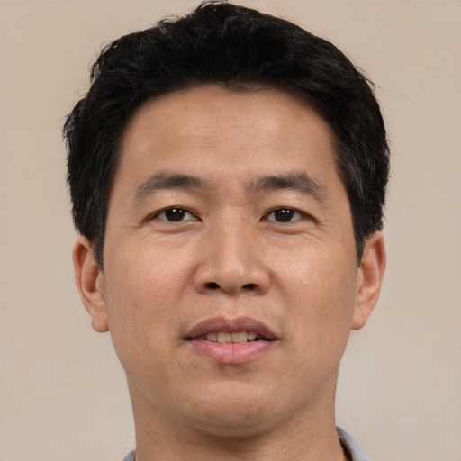 Joyful asian young-adult male with short  brown hair and brown eyes