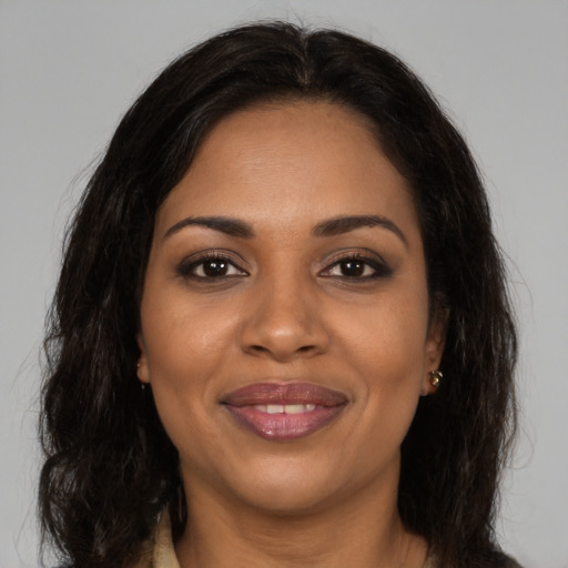 Joyful black young-adult female with long  brown hair and brown eyes