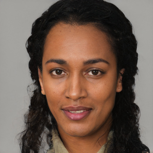 Joyful black young-adult female with long  black hair and brown eyes