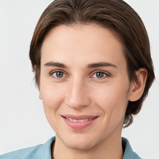 Joyful white young-adult female with medium  brown hair and grey eyes